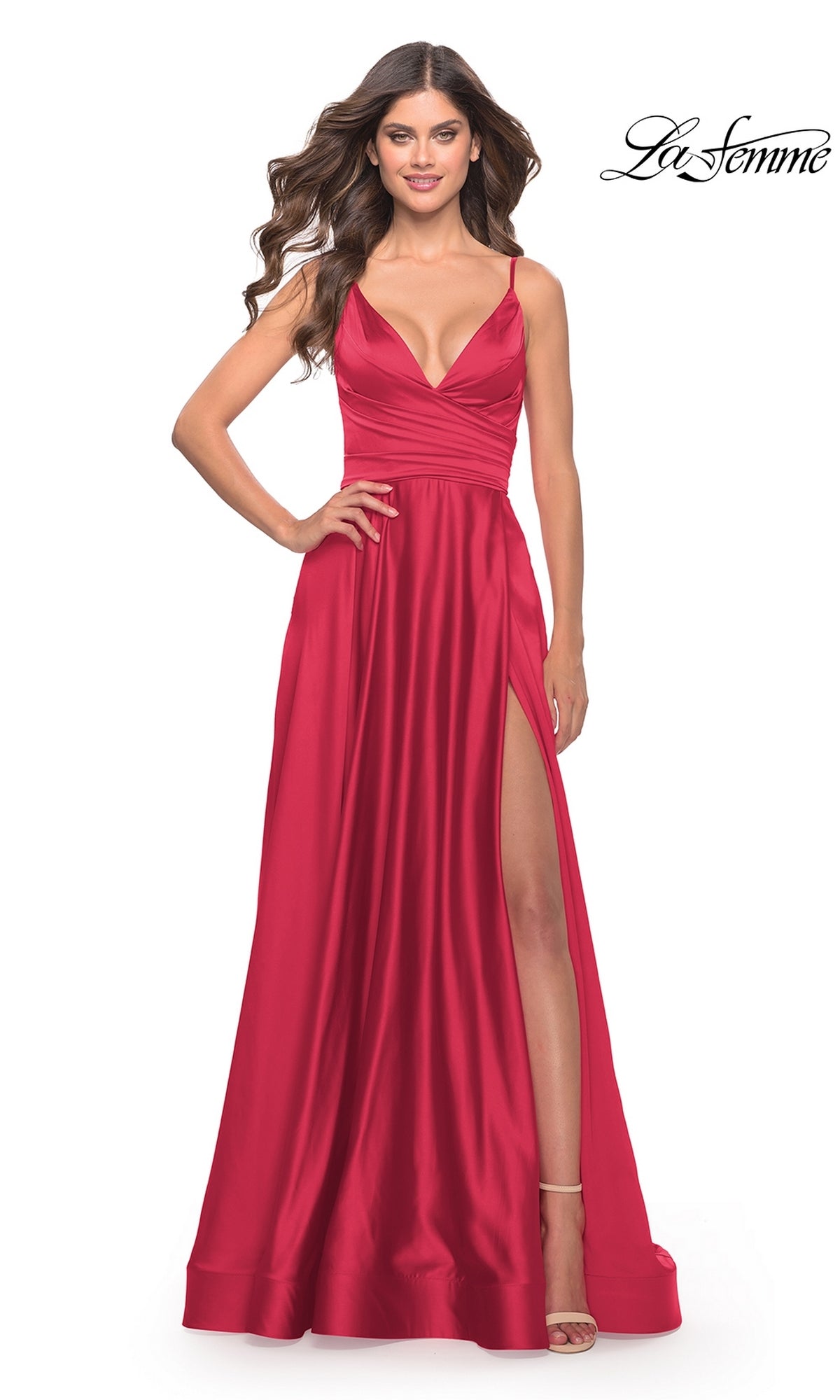 Woman wearing a sleeveless red La Femme V-Neck Long A-Line Prom Dress 28607 with a ruched waist and high slit, standing in heels against a white background.
